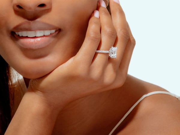 woman wearing a TACORI emerald and pavé diamonds cut engagement ring with a hidden halo