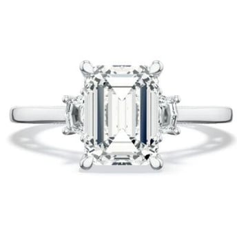 Three stone emerald cut engagement ring on platinum band